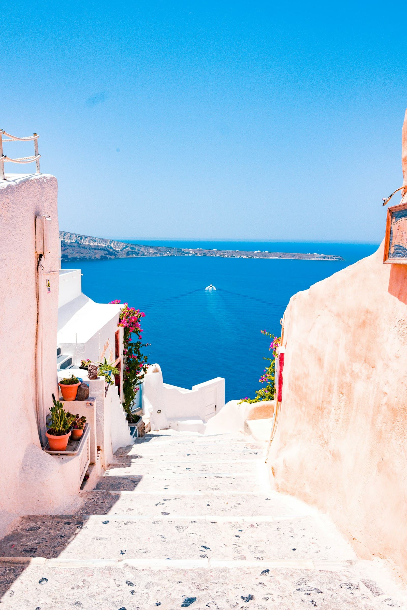 A blue-water coastline seen from a whitewashed hillside town