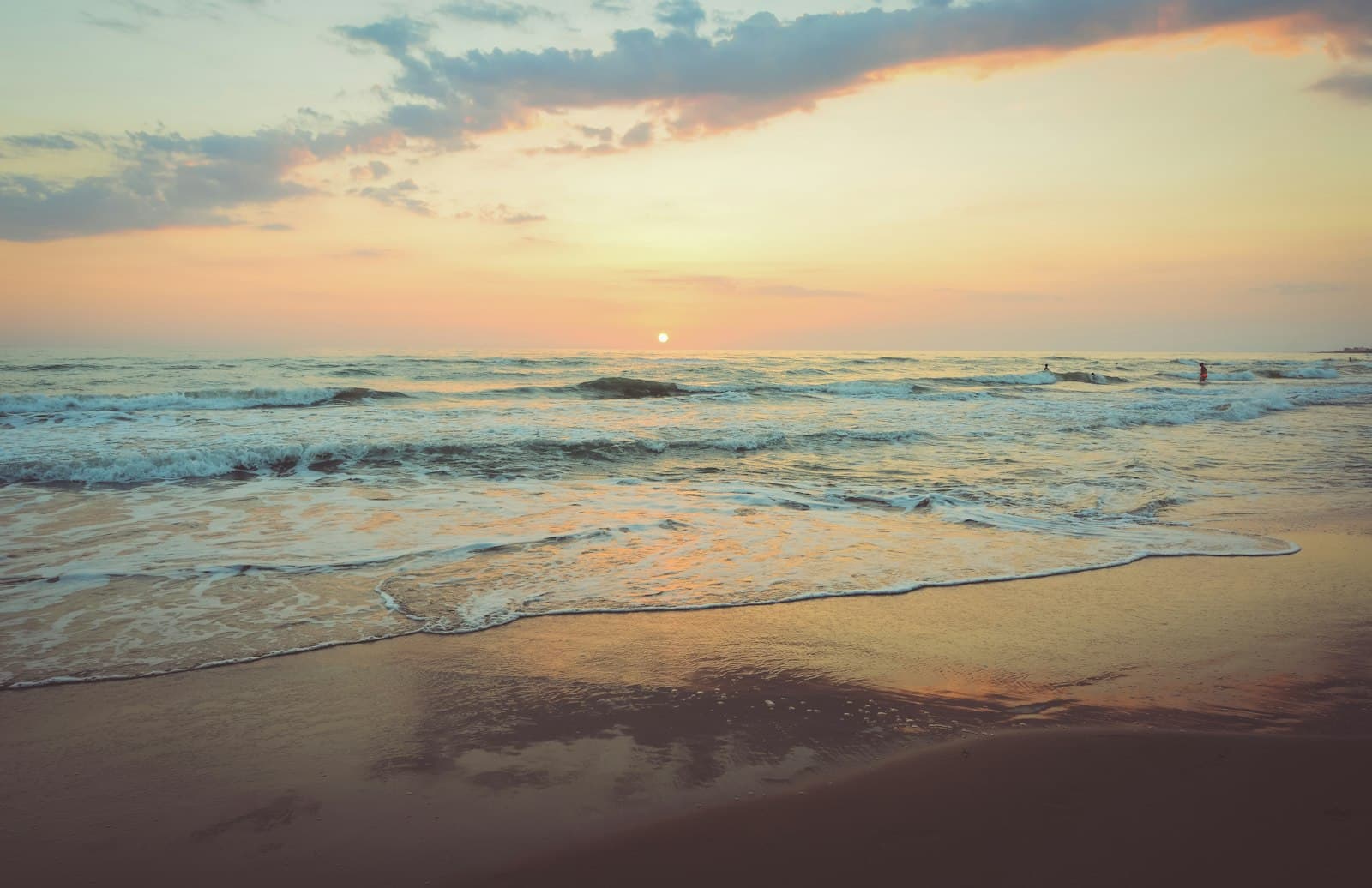 A soft, muted sunset over a quiet beach at dusk